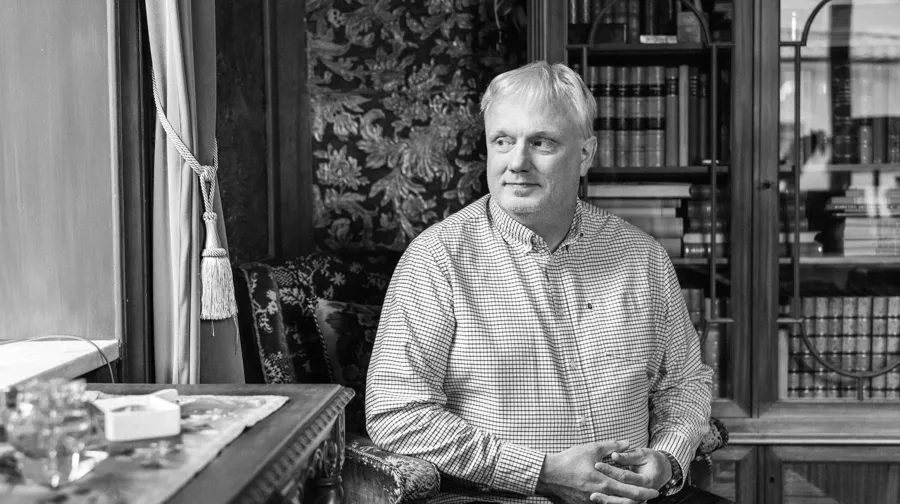 Ett svartvitt foto av en man som sitter i en stol.