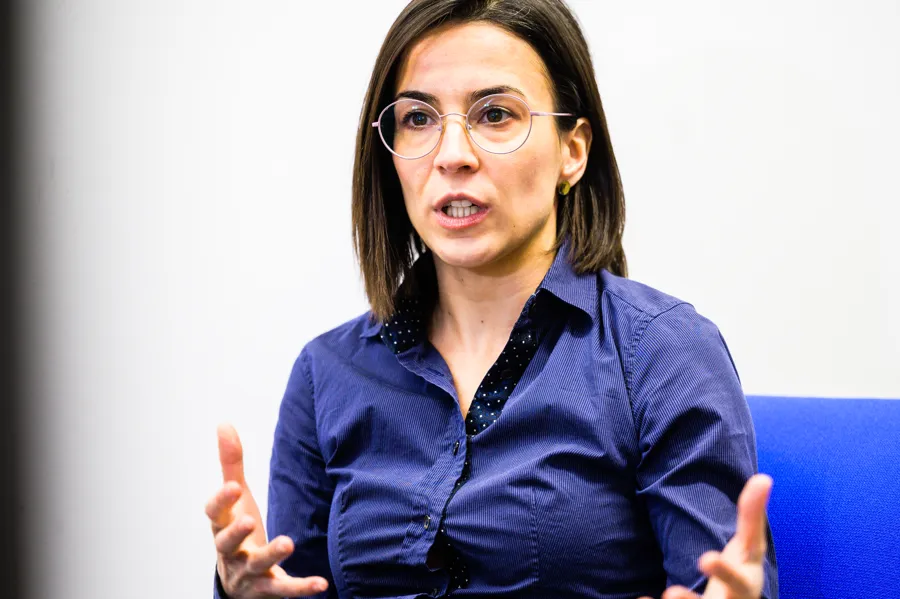 En kvinna i blå skjorta och glasögon.