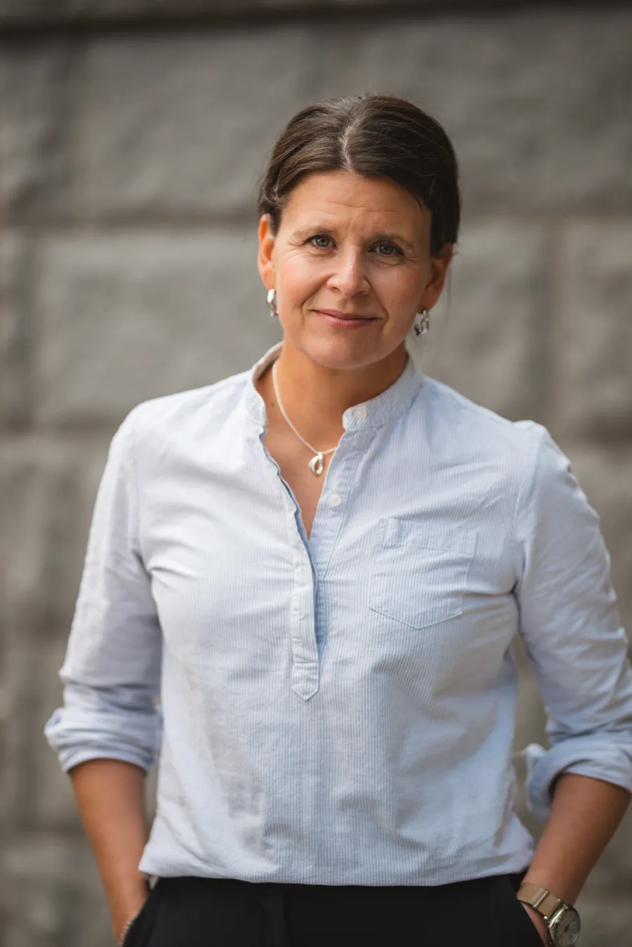 Porträttbild på en kvinna framför en stenvägg.