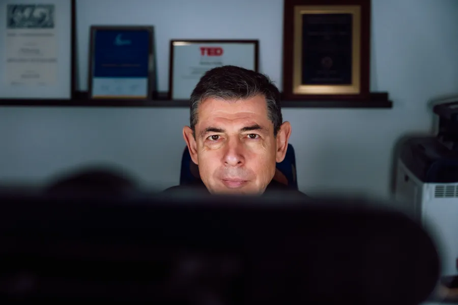 A man sitting in front of a computer monitor.