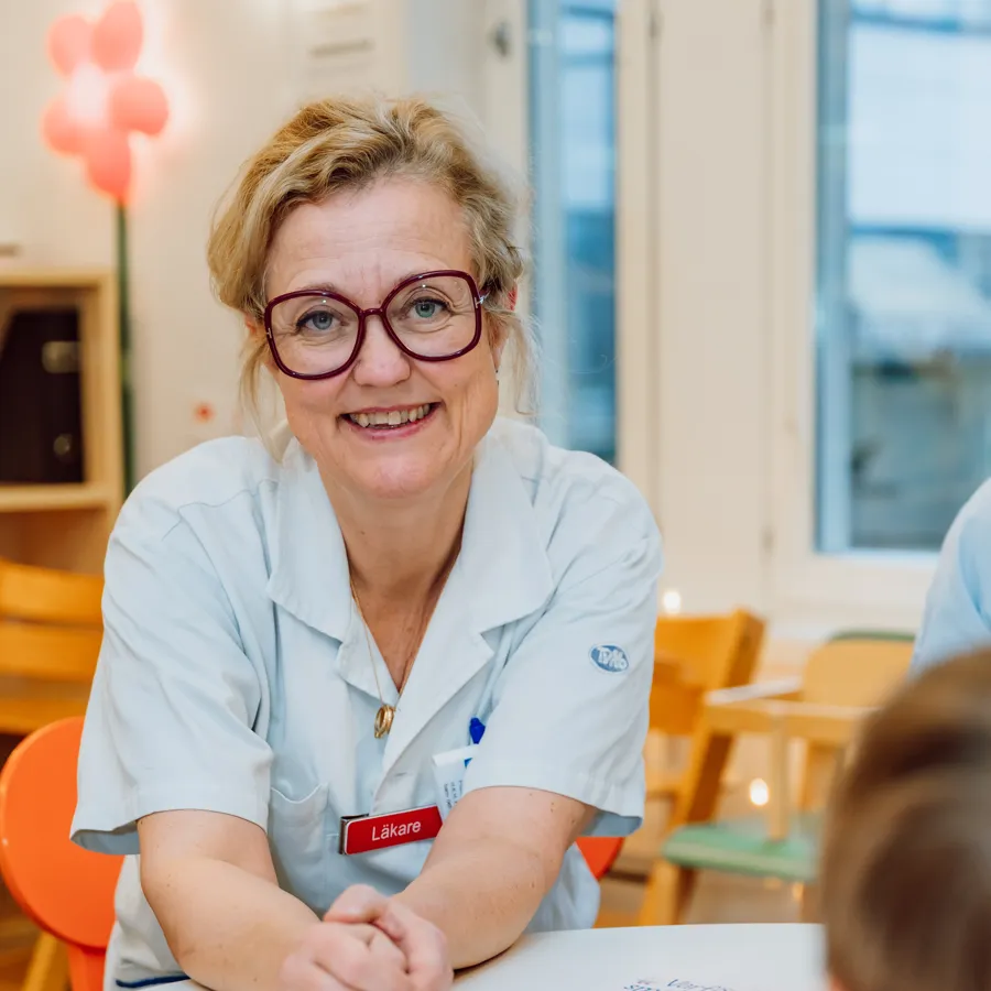 A woman sitting at a table with a child.