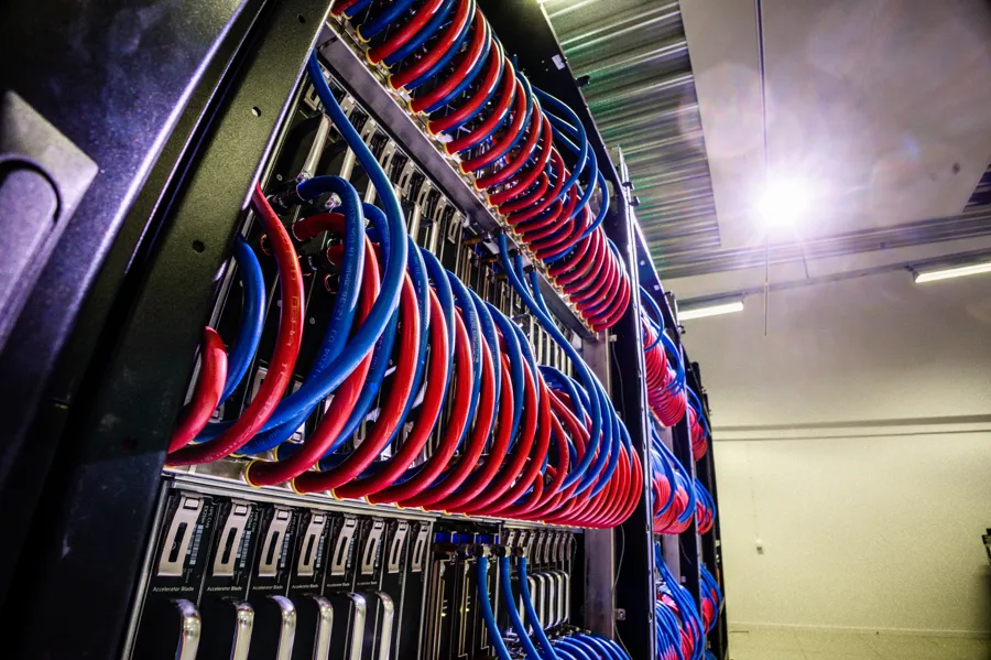 En hylla full med röda och blå kablar.