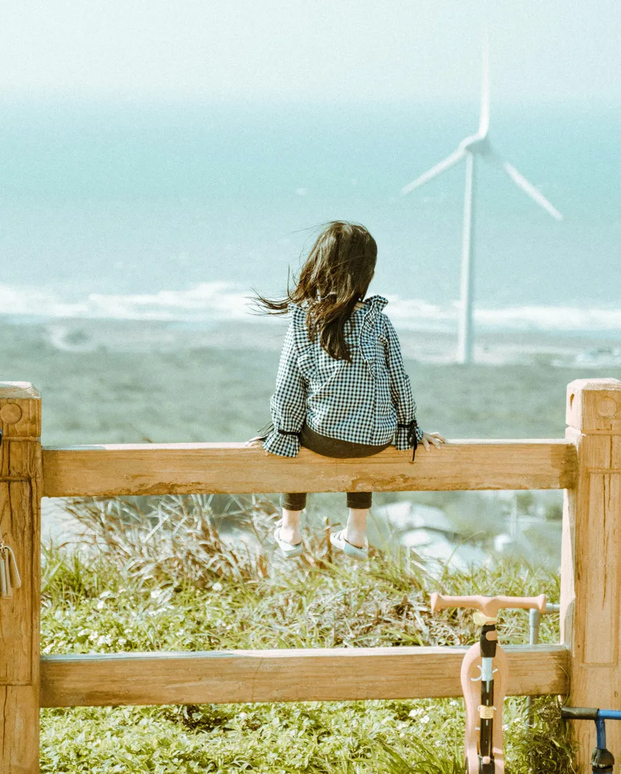 Flicka tittar på vindkraftverk.