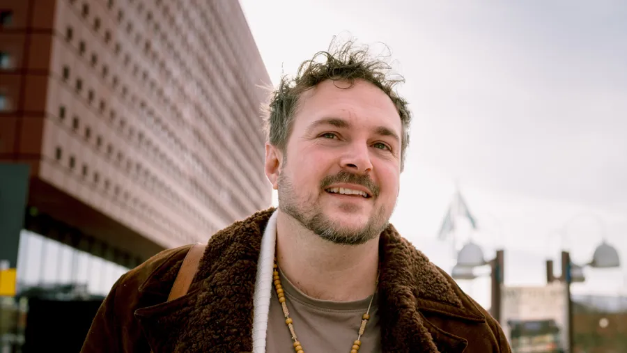 Man standing in front of Studenthuset Building on campus.