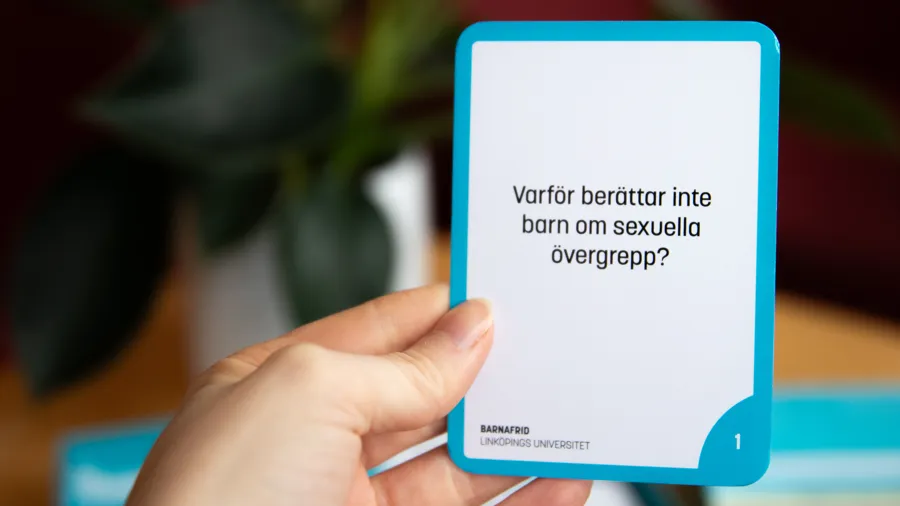 En hand som håller i ett frågekort.