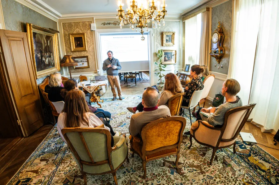 En grupp människor som sitter i stolar i ett rum.