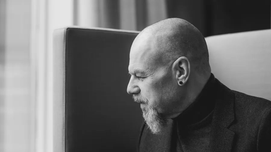 A man with a bald head sitting in a chair.