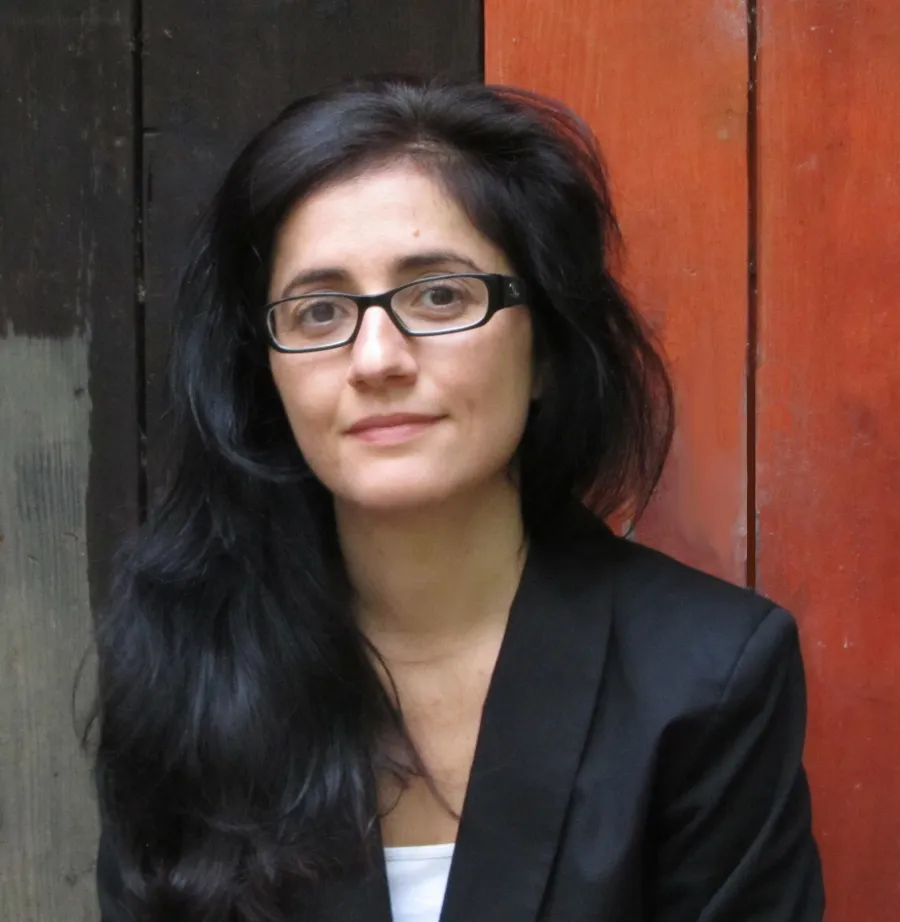 En kvinna framför en trävägg.