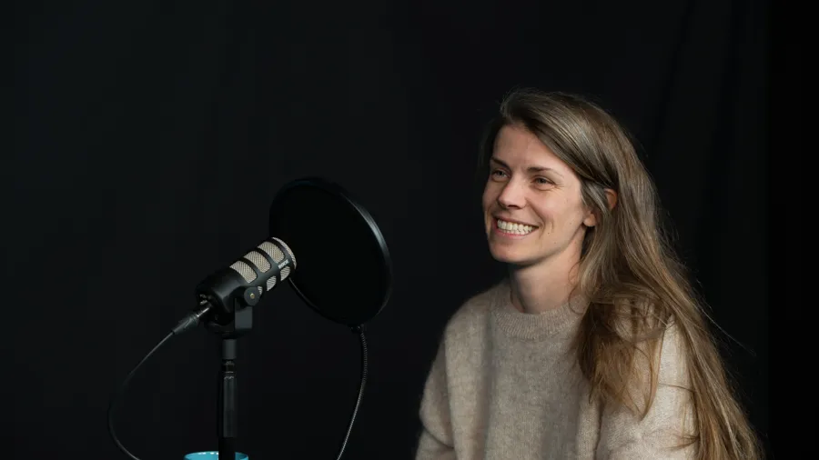 En person sitter i en poddstudio.