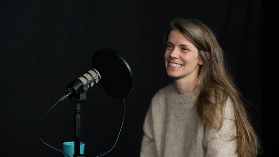 En person sitter i en poddstudio.