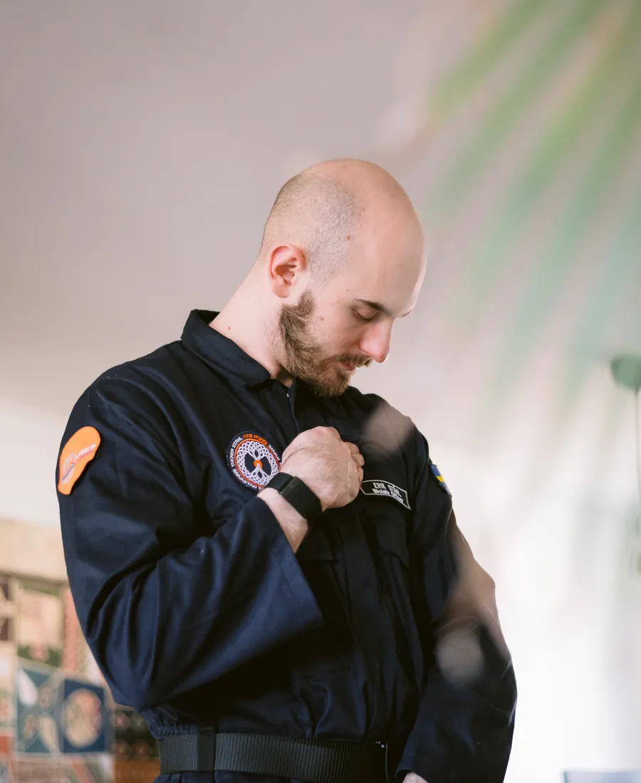 En man i uniform rättar till sin klädsel.