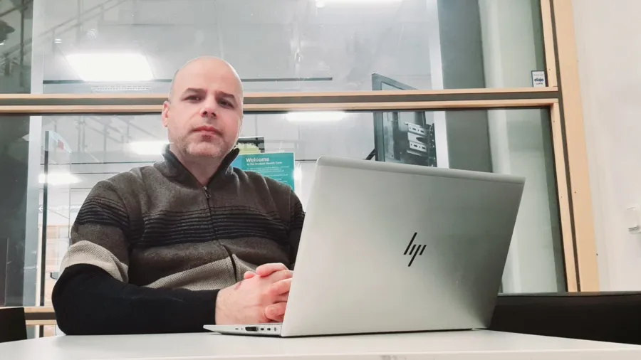 En man sitter framför en bärbar dator.