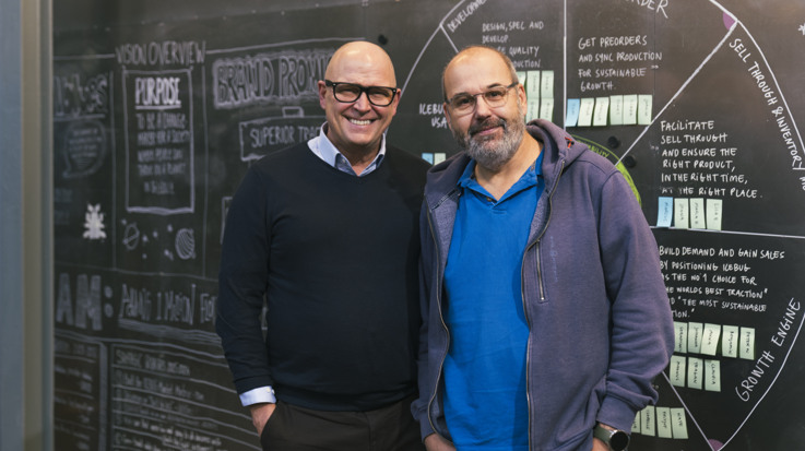 Två män står bredvid varandra framför en krittavla.