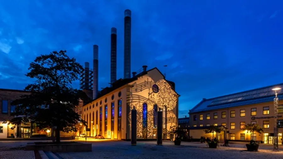 A building lit up at night with a clock tower in the background.