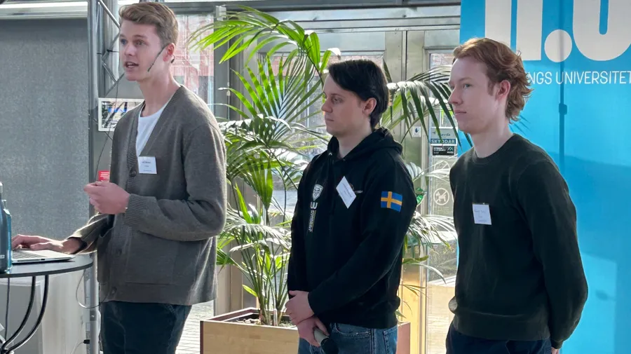 En grupp unga män som står runt ett bord.