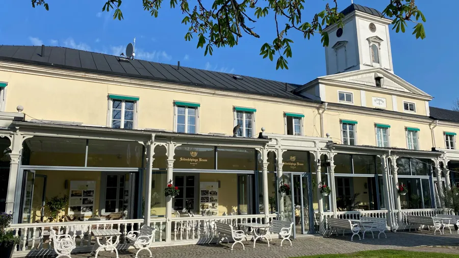 Söderköpings brunn, ett hus med veranda, bord och bänkar framför.