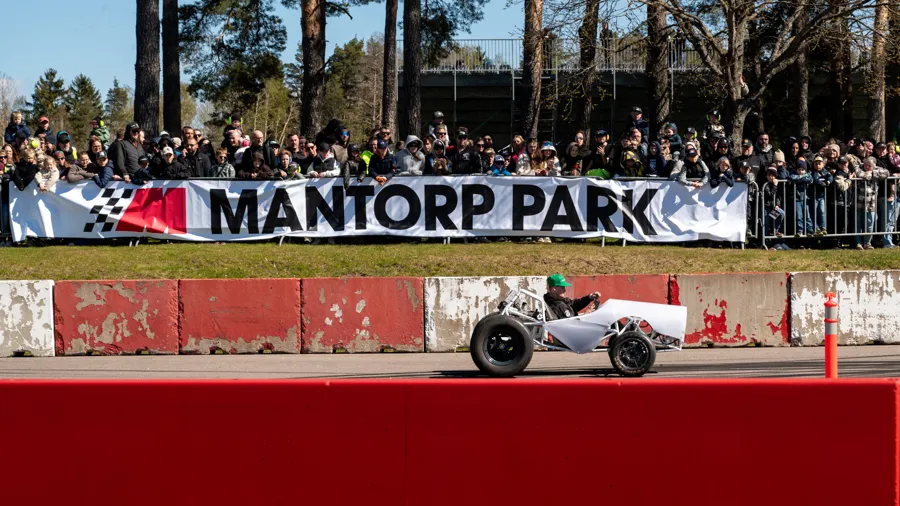 En person som kör en racerbil på en racerbana.