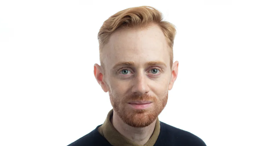 Porträttbild på en man mot en vit bakgrund.