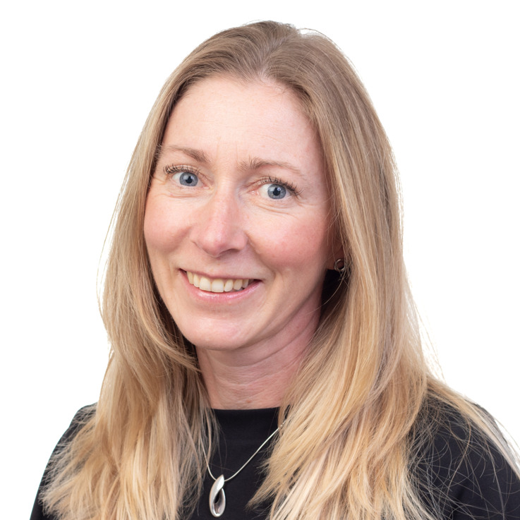 En kvinna med långt blont hår som bär en svart skjorta.