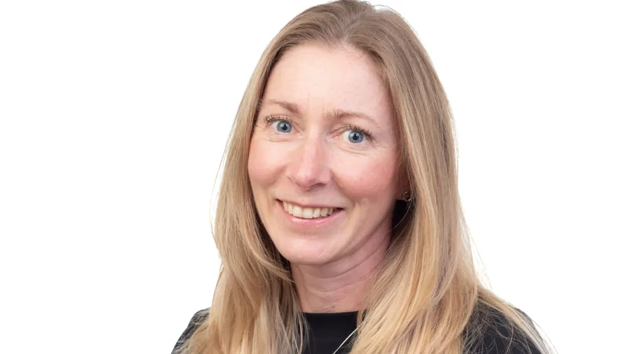 En kvinna med långt blont hår som bär en svart skjorta.