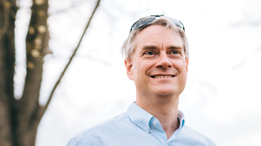 A man in a blue shirt is smiling.