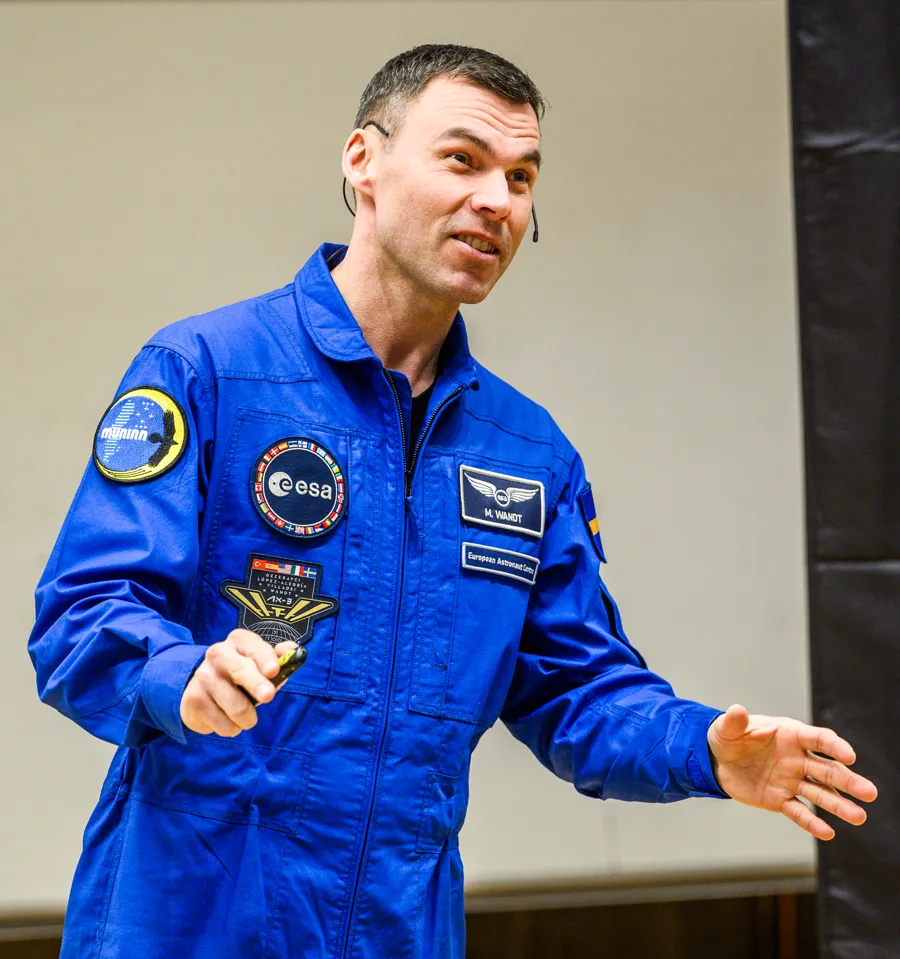 En man i blå rymddräkt.